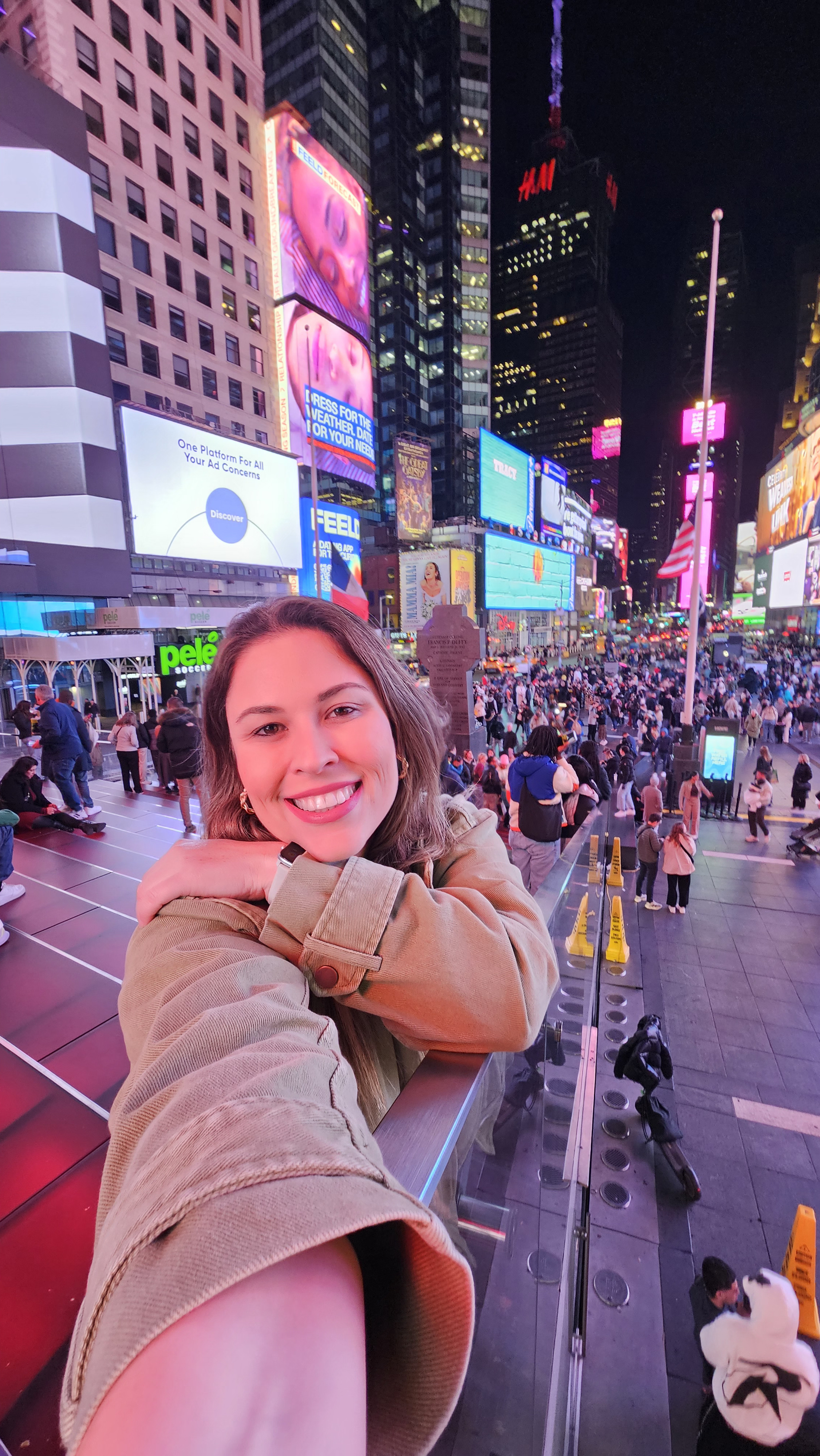 Mulher sozinha olhando o celular em uma rua movimentada de Nova York