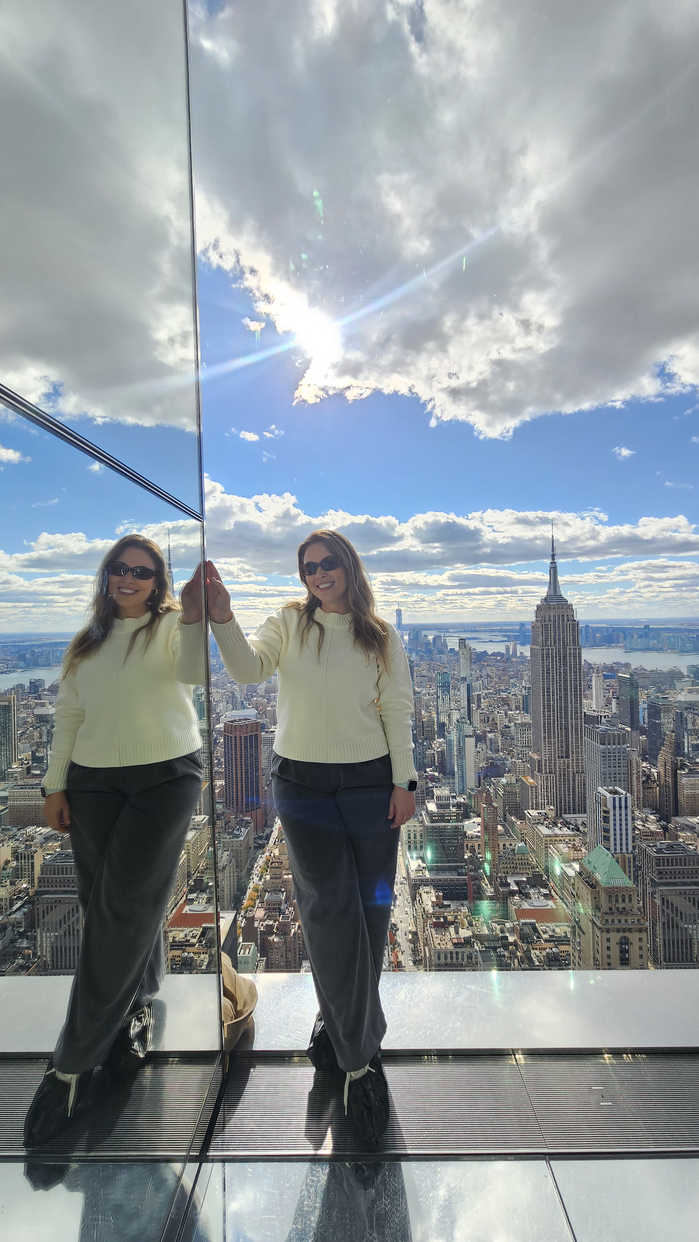 Mulher sorrindo com a vista de Nova York do alto, com o Empire State ao fundo